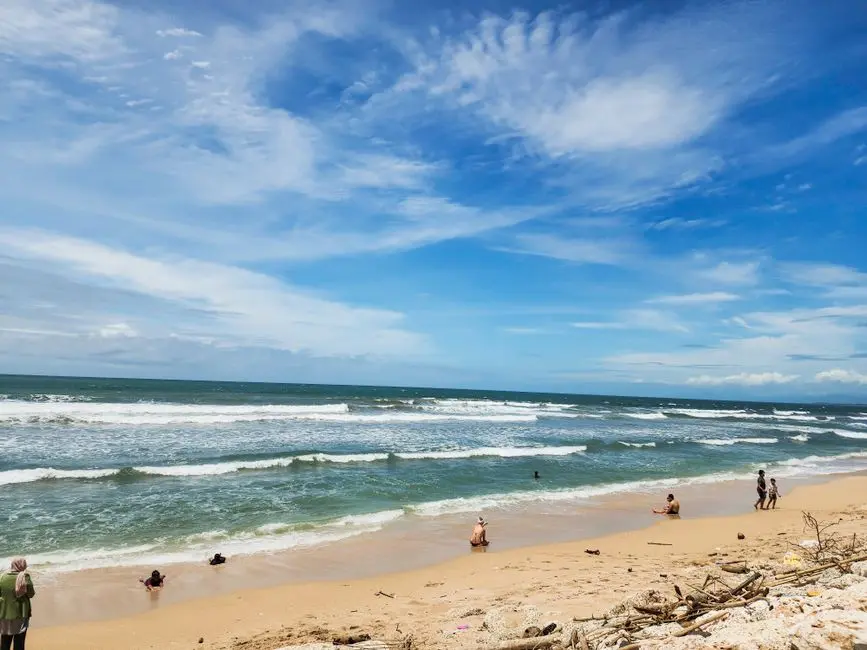 Pantai sederhana dengan pengunjung menikmati sore di sekitar Pinang