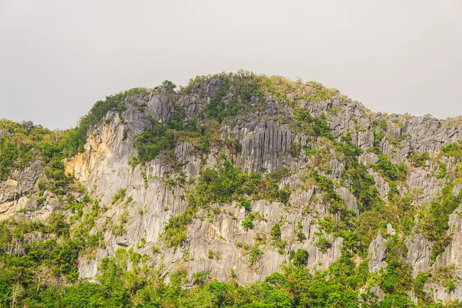Pemandangan Bukit Tampurung dari tebing karang dengan latar perbukitan hijau